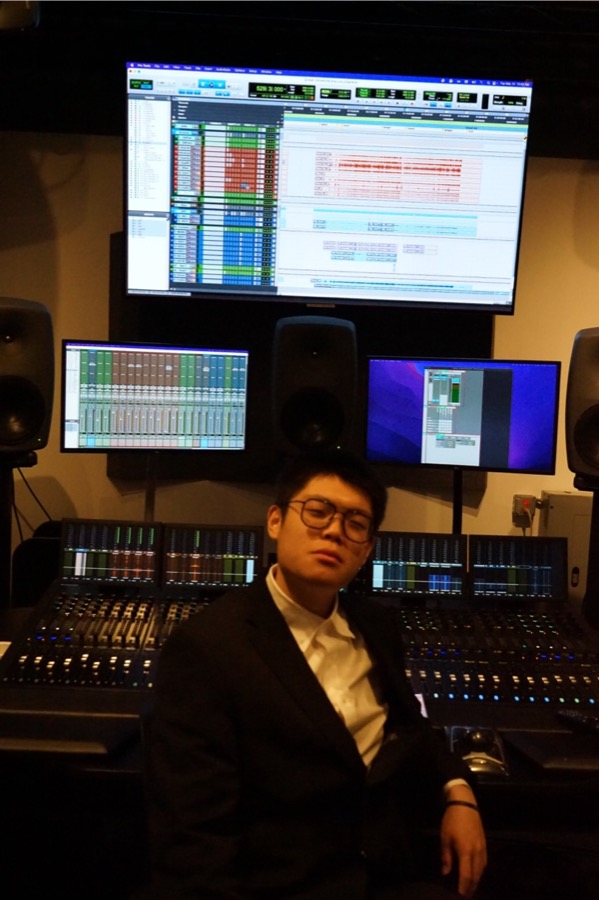 胡津豪坐在录音棚调音台前